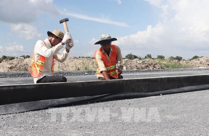 Công nhân đổ bê tông trên đường cất hạ cánh của Dự án mở rộng, nâng cấp Cảng hàng không Cà Mau. Ảnh: Tuấn Phi - TTXVN