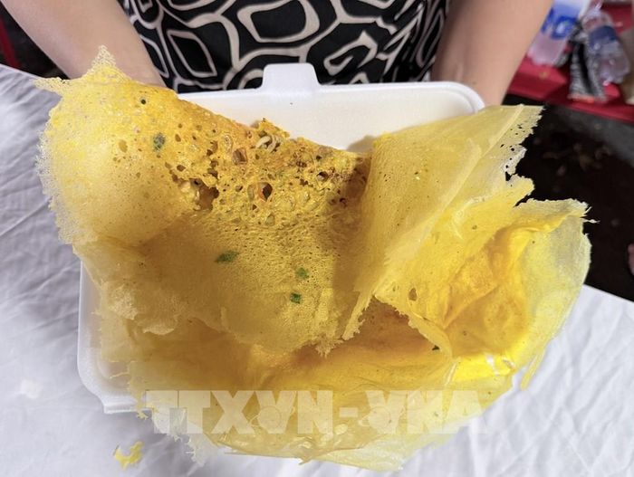 Bánh xèo vàng óng, thơm lừng vừa ra khỏi chảo, hấp dẫn thực khách. Ảnh: Thanh Sang - TTXVN