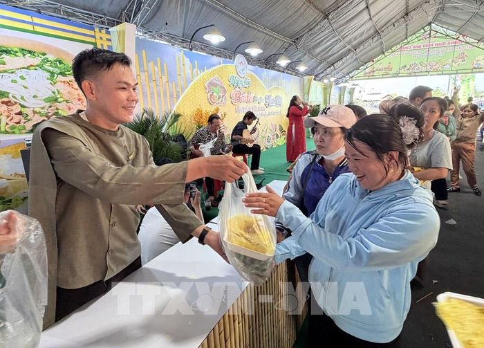 Du khách thích thú nhận bánh xèo do các nghệ nhân và đầu bếp chế biến tại ngày hội. Ảnh: Thanh Sang - TTXVN