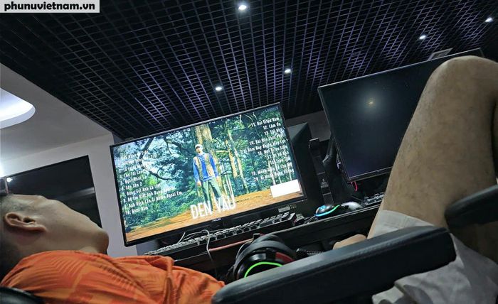 Xen giữa những người đang chơi game là một thanh niên kê ghế nằm ngủ.