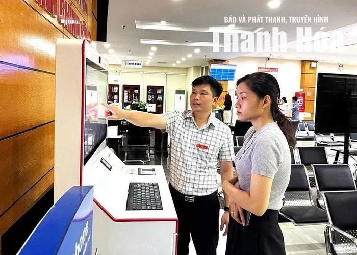 Công chức Trung tâm Phục vụ hành chính công tỉnh hướng dẫn công dân thực hiện thủ tục hành chính trên Kiosk thông minh. Ảnh: Tố Phương