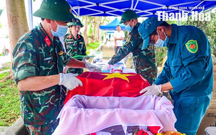 Từng phần hài cốt được nâng niu, bọc cẩn thận trong lá cờ Tổ quốc trước khi hoàn tất các bước lấy mẫu, niêm phong và bảo quản.