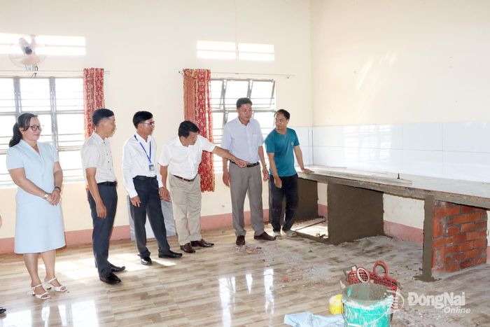 Phó Giám đốc Sở Giáo dục và Đào tạo Phạm Hồng Thắng cùng lãnh đạo địa phương kiểm tra việc xây dựng bếp ăn cho học sinh tại Trường tiểu học Đăk Á. Ảnh: Quang Minh