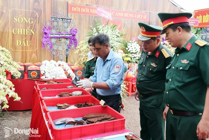 Thành viên Đội K72 thông tin về các di vật của liệt sĩ đã tìm thấy và đang được làm sạch để bảo quản. Ảnh: Nguyệt Hà