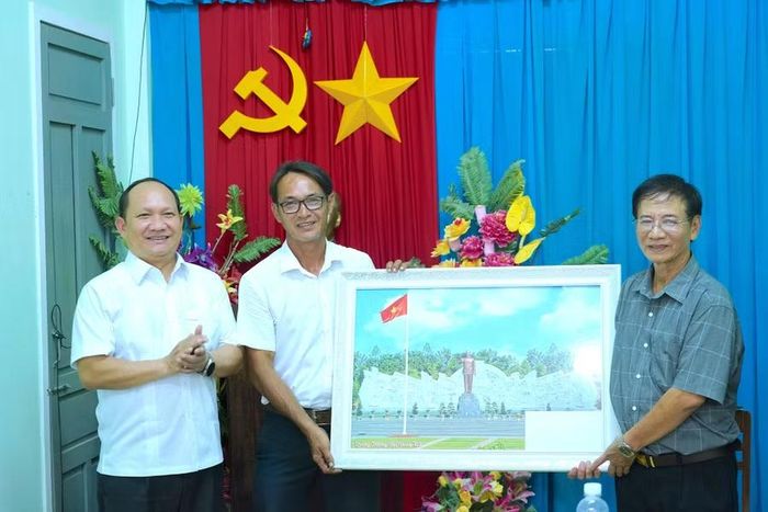 Phó Bí thư Thường trực Tỉnh ủy Rah Lan Chung (bìa trái) tặng bức ảnh Tượng đài Bác Hồ với các dân tộc Tây Nguyên tại Quảng trường Đại Đoàn Kết (phường Pleiku) cho Chi bộ tổ dân phố 1 (Hải Minh). Ảnh: N.H