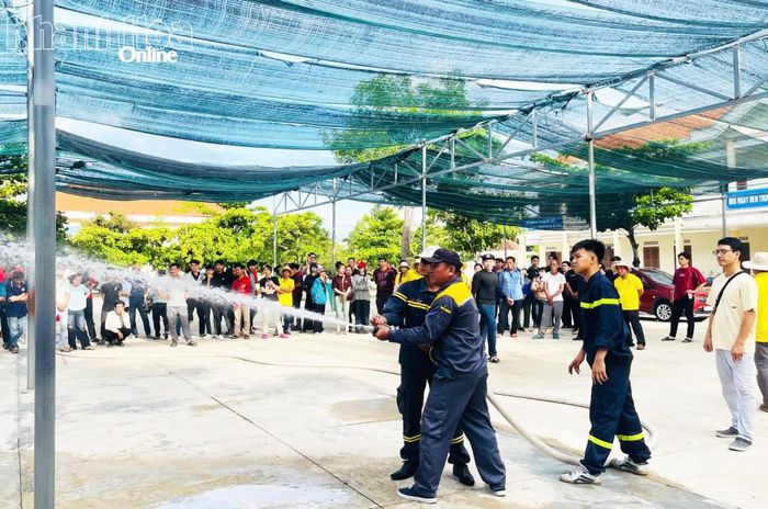 Chiến sĩ chữa cháy hướng dẫn học viên kỹ năng sử dụng lăng chữa cháy để dập lửa.