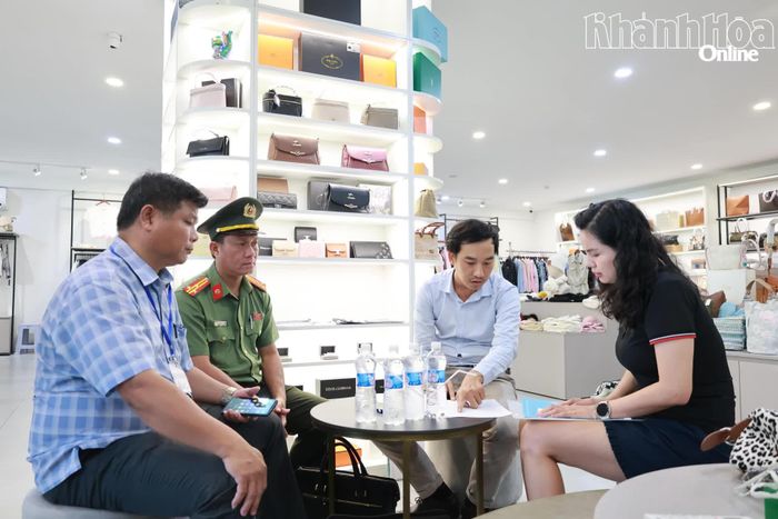 Lực lượng chức năng làm việc với đại diện cơ sở kinh doanh trên đường Hùng Vương.