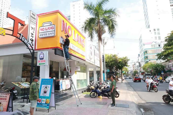 Chủ cơ sở kinh doanh trên đường Nguyễn Thiện Thuật chủ động tháo bảng hiệu quảng cáo không đúng quy định.