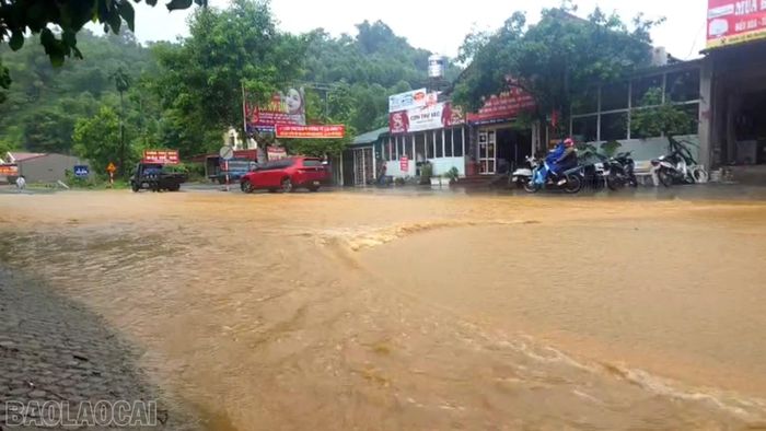 Các phương tiện di chuyển chậm qua khu vực ngập cục bộ tại thôn Tòng Mòn, xã Cốc San.