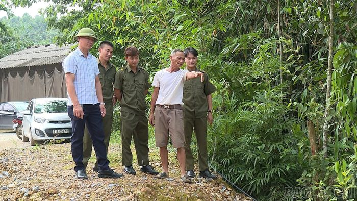 Ông Nguyễn Văn Lang (áo trắng) lo ngại khi mực nước con suối gần nhà dâng cao trong những ngày mưa lớn.
