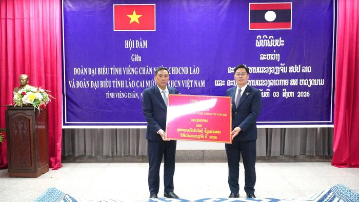 Đồng chí Hoàng Giang trao kinh phí hỗ trợ mua thiết bị máy tính cho tỉnh Viêng Chăn.
