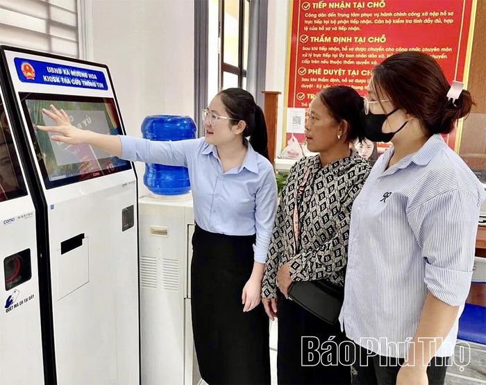Cán bộ Trung tâm Phục vụ hành chính công hướng dẫn người dân lấy số tự động khi đến làm thủ tục hành chính.