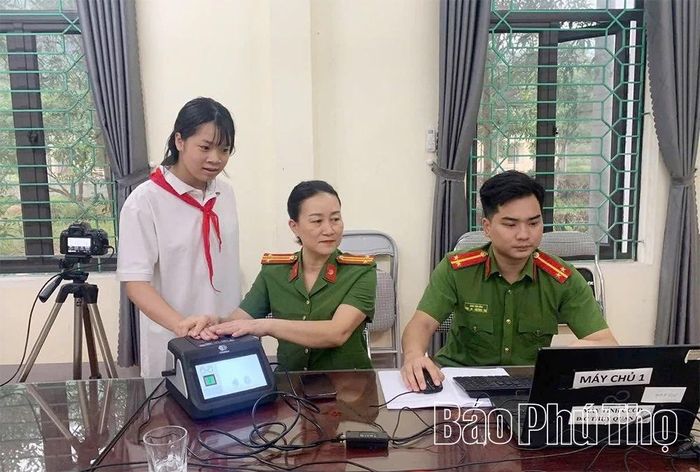 Lực lượng Công an xã hướng dẫn học sinh thực hiện thủ tục cấp căn cước và kích hoạt định danh điện tử.