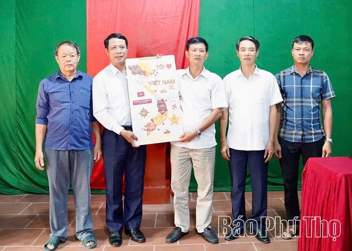 Đồng chí Trưởng Ban Tổ chức Tỉnh ủy Bùi Đình Thi trao tặng quà cho Chi bộ thôn Lục Thụ.