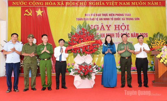 Đồng chí Phó Chủ tịch HĐND tỉnh Phạm Thị Minh Xuân và lãnh đạo Công an tỉnh tặng hoa chúc mừng tại Ngày hội Toàn dân bảo vệ an ninh Tổ quốc tại xã Trung Sơn.