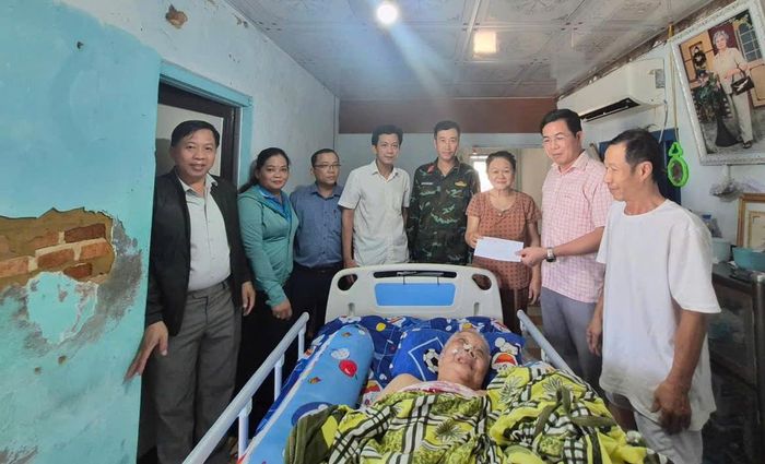Ông Nguyễn Đăng Vinh, Bí thư Đảng ủy xã Tư Nghĩa (thứ 2 từ phải qua) tặng quà động viên gia đình bà Lan.