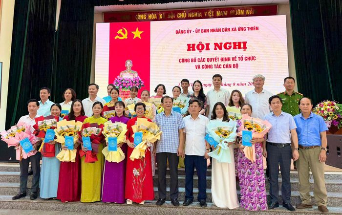 Lãnh đạo xã Ứng Thiên tặng hoa chúc mừng các cán bộ quản lý các nhà trường. Ảnh: Vân Nga