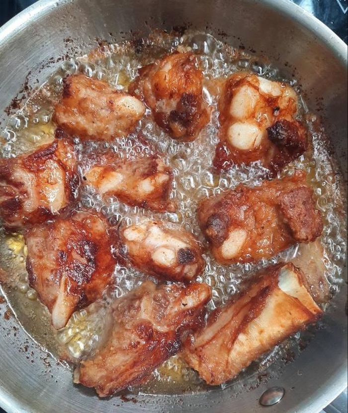 Chiên sườn: Cho dầu vào chảo đun nóng rồi thả sườn vào chiên lửa vừa cho vàng giòn đều. Khi sườn chín tới, tăng lửa lớn lên một xíu rồi hãy vớt ra để cho sườn không bị ngấm dầu. Ảnh: Hoang Trang