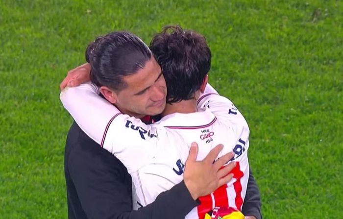 Jonathan Dos Santos (áo đen) ôm con trai sau khi trận đấu kết thúc.