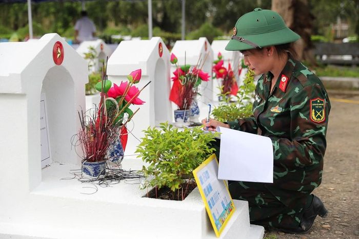 Cán bộ Bộ Chỉ huy Quân sự tỉnh Thanh Hóa rà soát, ghi nhận thông tin tại phần mộ liệt sĩ, phục vụ công tác lấy mẫu và xác định danh tính bằng ADN. Ảnh: Trần Huấn
