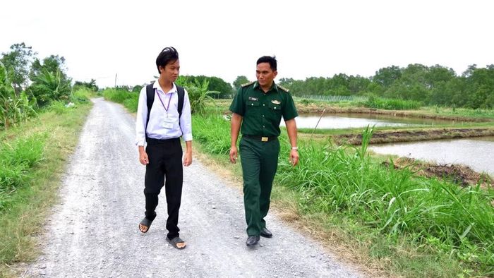 Con nuôi Phạm Văn Giàu chia sẻ ước mơ về con đường học tập cùng Thượng úy Thạch Minh Sỹ. (Ảnh: LÊ KHOA)