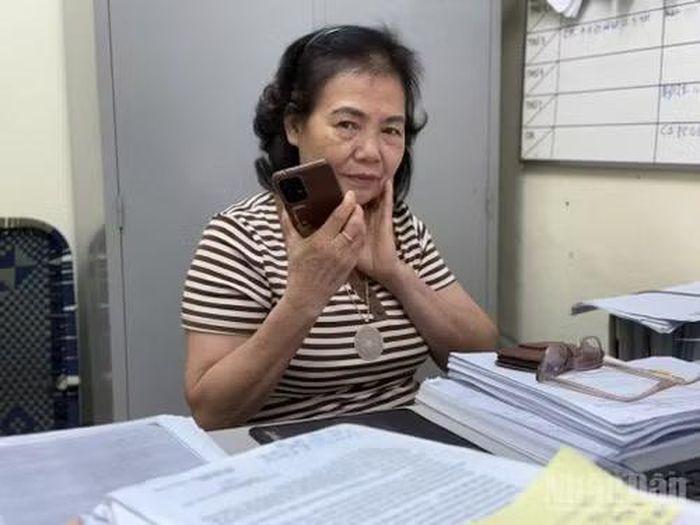 Chiếc điện thoại trở thành công cụ làm việc bất ly thân và hằng ngày, hằng giờ, cô tiếp nhận không biết bao cuộc điện thoại để tư vấn hỗ trợ thân nhân liệt sĩ. (Ảnh: KIM DUNG)