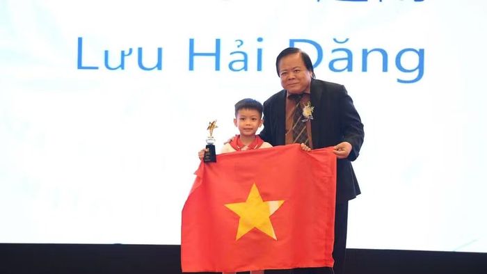 Học sinh Lưu Hải Đăng, lớp 2, Trường tiểu học và trung học cơ sở Hà Nội - Thăng Long (Hà Nội) được Ban tổ chức trao Cúp International Star. (Ảnh: Ban tổ chức cung cấp)