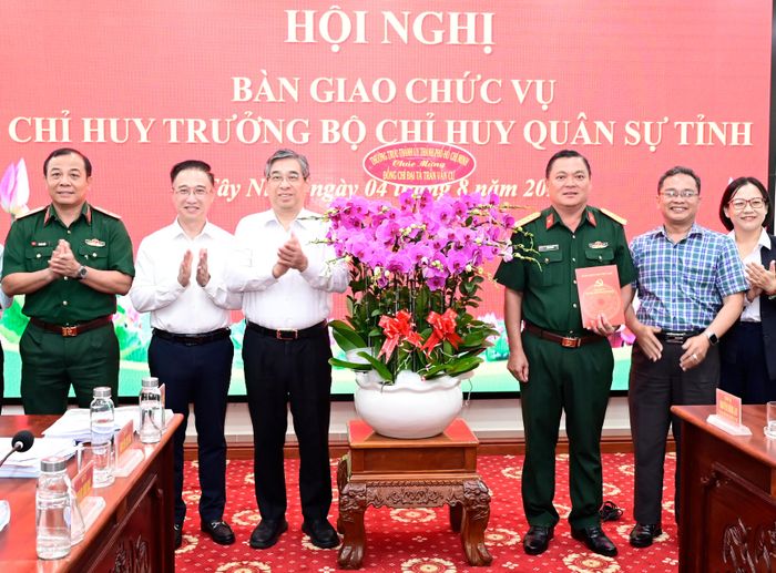  Đồng chí Nguyễn Phước Lộc và đồng chí Đặng Minh Thông tặng hoa chúc mừng Đại tá Trần Văn Cư nhận nhiệm vụ mới. Ảnh: VĂN MINH 