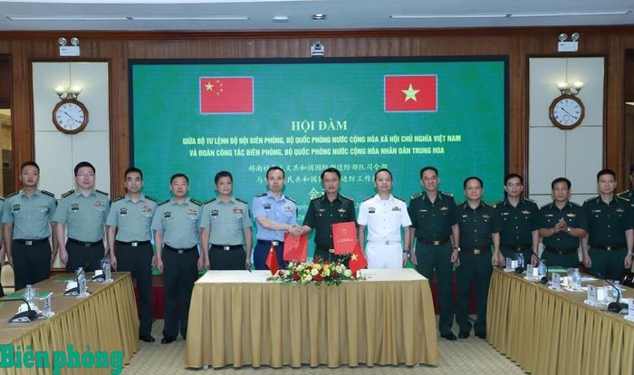 Đại tá Trần Nam Trung và Đại tá Lưu Hải Long trao biên bản ghi nhớ hội đàm. Ảnh: Ngọc Lâm