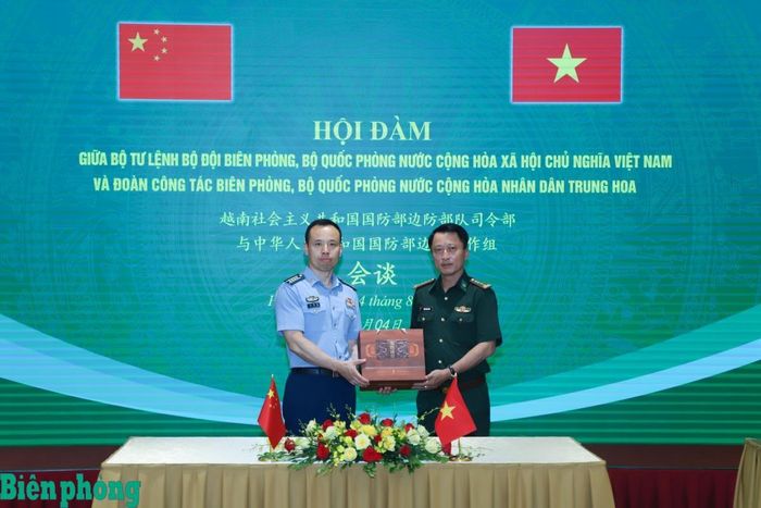 Đại tá Lưu Hải Long trao quà tặng Đại tá Trần Nam Trung. Ảnh: Ngọc Lâm