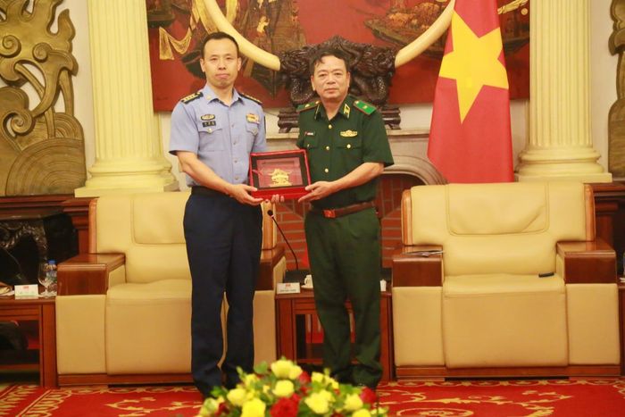 Thiếu tướng Nguyễn Văn Thiện trao quà tặng Đại tá Lưu Hải Long tại buổi tiếp. Ảnh: Cẩm Linh