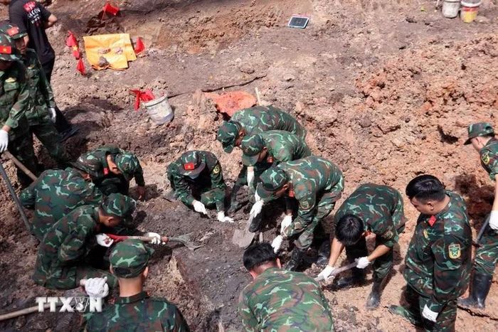 Cán bộ, chiến sỹ Đội tìm kiếm, quy tập hài cốt liệt sỹ làm việc tại địa điểm khai quật khu B của Công viên Lê Thị Riêng. (Ảnh: Xuân Khu/TTXVN)