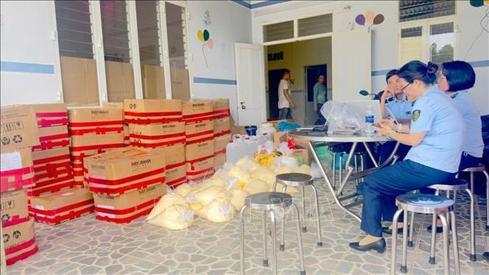 Cán bộ Quản lý thị trường kiểm đếm các bao nguyên liệu và thiết bị phục vụ sản xuất mỹ phẩm bị tạm giữ tại hiện trường.