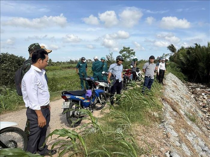 Đoàn công tác và các ngành chức năng địa phương tiến hành rà soát, đánh giá mức độ rạn nứt của thân đê để lên phương án gia cố khẩn cấp. Ảnh: TTXVN phát