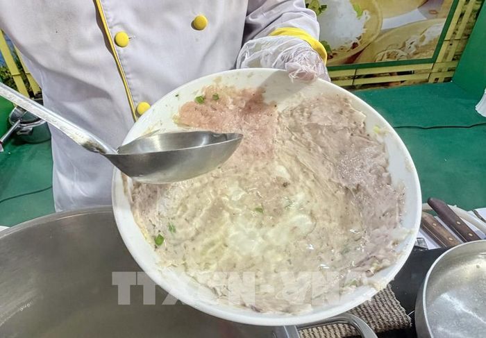 Nước dùng sôi được chan trực tiếp vào tô, làm chín lớp chả mực, chả tôm quết trên thành tô đây là công đoạn đặc trưng của món bún quậy Phú Quốc (An Giang). Ảnh: Thanh Sang-TTXVN