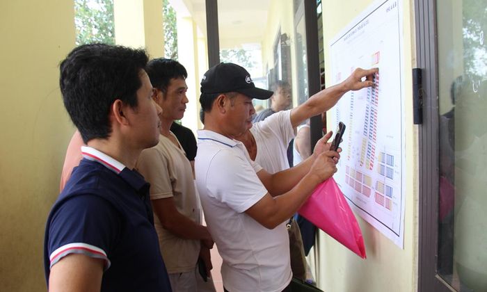 Người dân phấn khởi xác định vị trí lô đất của gia đình mới bốc thăm trên bản đồ quy hoạch khu tái định cư.