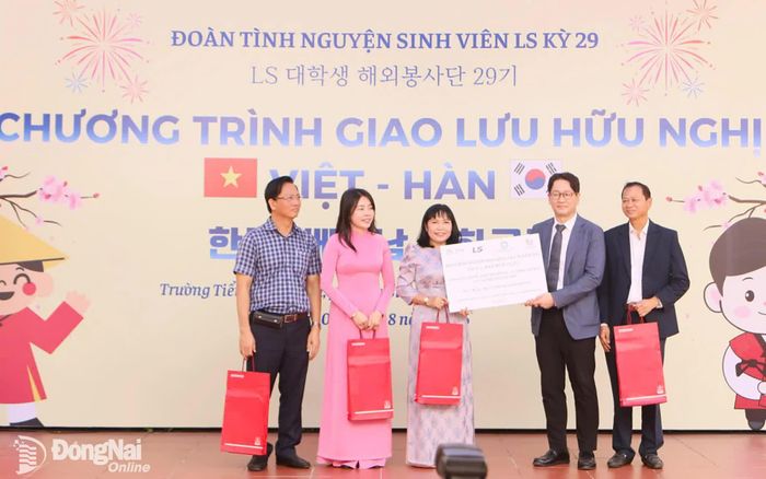 Đại diện Tập đoàn LS, Công ty TNHH Cáp điện và Hệ thống LS Việt Nam, Tổ chức COPION trao bảng biểu trưng kinh phí hỗ trợ cho lãnh đạo Trường tiểu học Hóa An. Ảnh: Văn Truyên