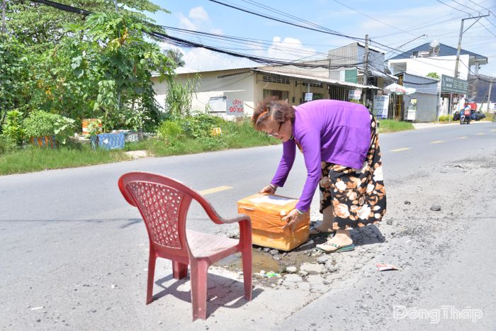 Bà Ánh phải đặt ghế, thùng xốp tại ổ gà trên đường phía trước nhà để cảnh báo người đi đường.