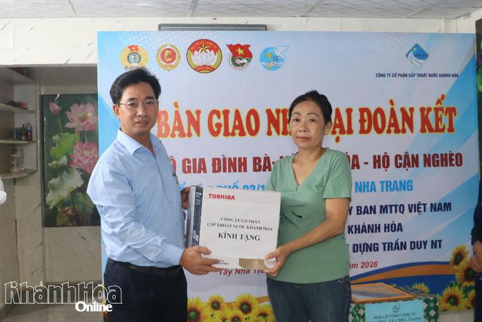 Lãnh đạo Công ty Cổ phần Cấp thoát nước Khánh Hòa trao quà cho gia đình bà Hóa.
