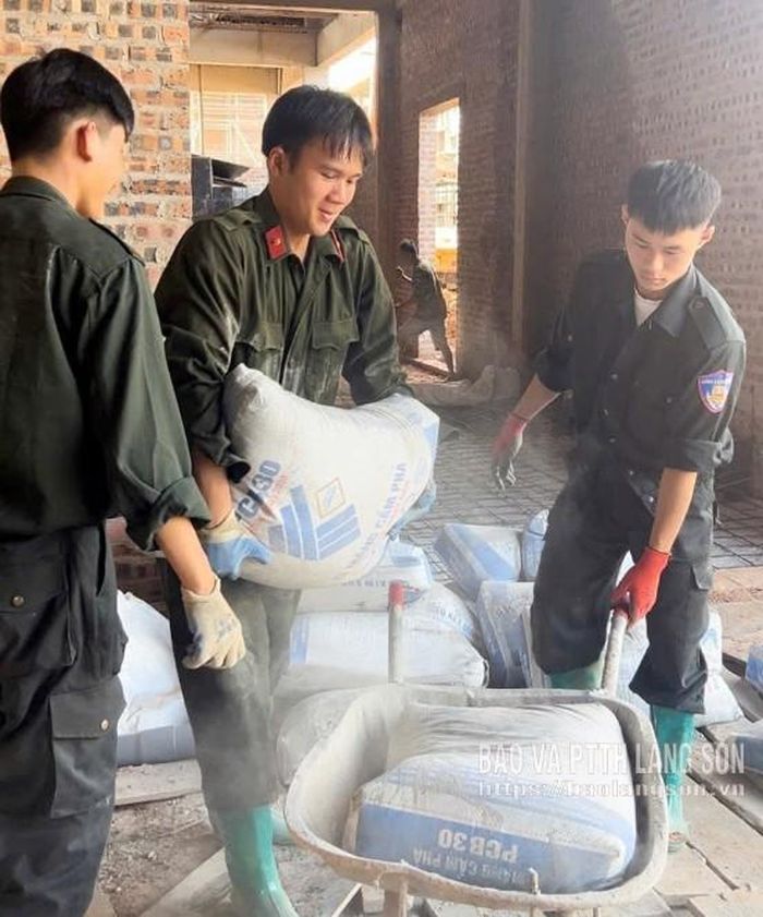 Cán bộ, chiến sĩ Phòng Cảnh sát cơ động, Công an tỉnh hỗ trợ vận chuyển xi măng tại công trình Trường Phổ thông nội trú liên cấp Tiểu học và THCS Quốc Khánh, xã Quốc Khánh