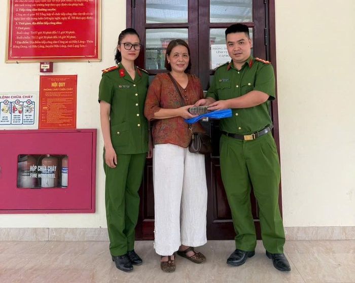 Đ/c Đại úy Nguyễn Chí Hào và Thượng úy Hoàng Thị Thủy trao trả số tiền 80.000 cho người dân để quên khi đến làm thủ tục hành chính