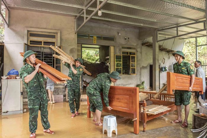 Cán bộ, chiến sĩ Đồn Biên phòng Cửa khẩu Quốc tế Lào Cai di dời khẩn cấp tài sản cho hộ ông Lý Vàn Tập có nhà bị sập do sạt lở đất.