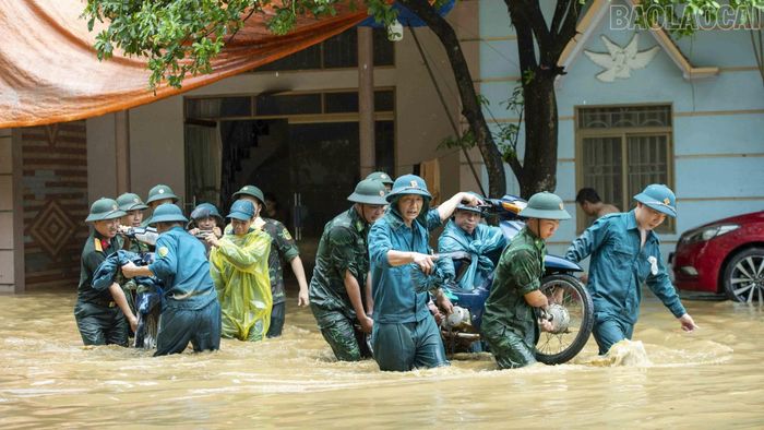 Cán bộ, chiến sĩ Đồn Biên phòng Cửa khẩu Quốc tế Lào Cai giúp người dân khắc phục hậu quả thiên tai.
