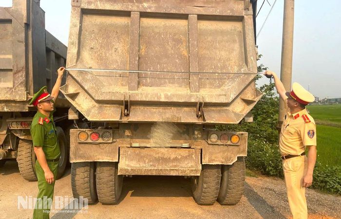 Lực lượng chức năng kiểm tra dấu hiệu cơi nới thành thùng xe trên phương tiện vận tải.