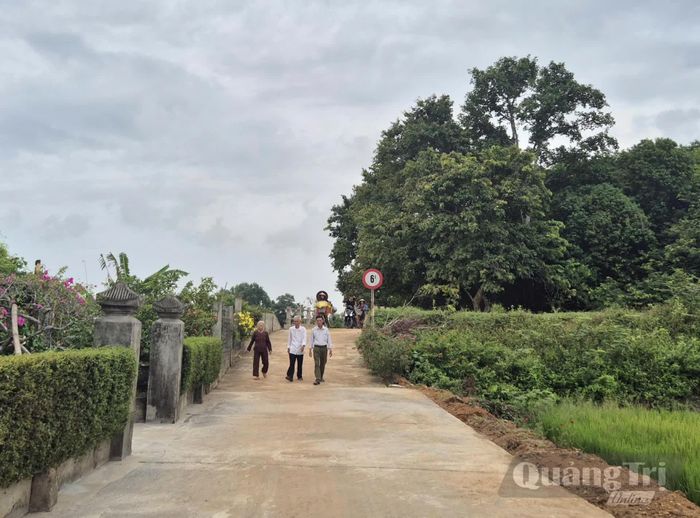 Ông Nguyễn Văn Thuận (giữa) cùng người dân đi trên con đường được mở rộng từ sự đồng thuận hiến đất, đóng góp công và kinh phí của người dân - Ảnh: K.S