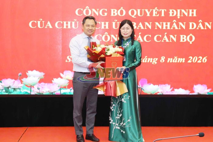 Đồng chí Nguyễn Đình Việt trao quyết định và tặng hoa chúc mừng đồng chí Hà Thị Ngọc Yến.