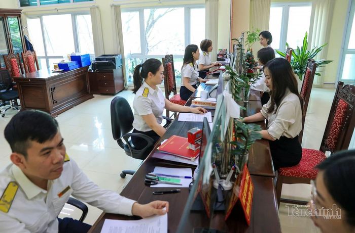 Công chức Thuế tỉnh Điện Biên hỗ trợ người nộp thuế làm sạch mã số thuế. Ảnh: Đức Thanh