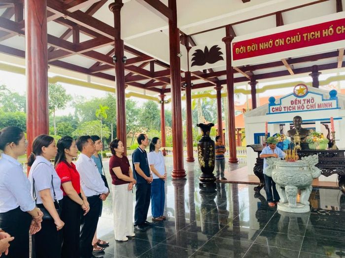Ông Nguyễn Văn Khoa giúp đoàn thắp hương tại Đền thờ Bác - Ảnh: B. Minh