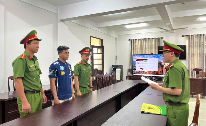 Tống đạt Quyết định khởi tố Nguyễn Đình Tuấn. Ảnh: CA.