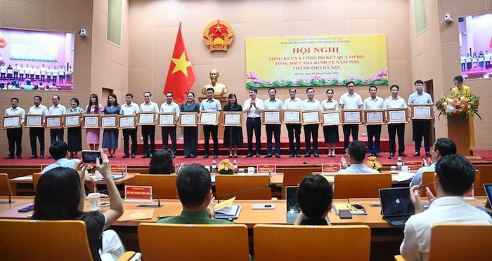 Phó Chủ tịch UBND thành phố Hà Nội Nguyễn Xuân Lưu trao Bằng khen của Chủ tịch UBND thành phố cho các tập thể có thành tích xuất sắc trong triển khai Tổng điều tra kinh tế năm 2026 trên địa bàn. Ảnh: TA